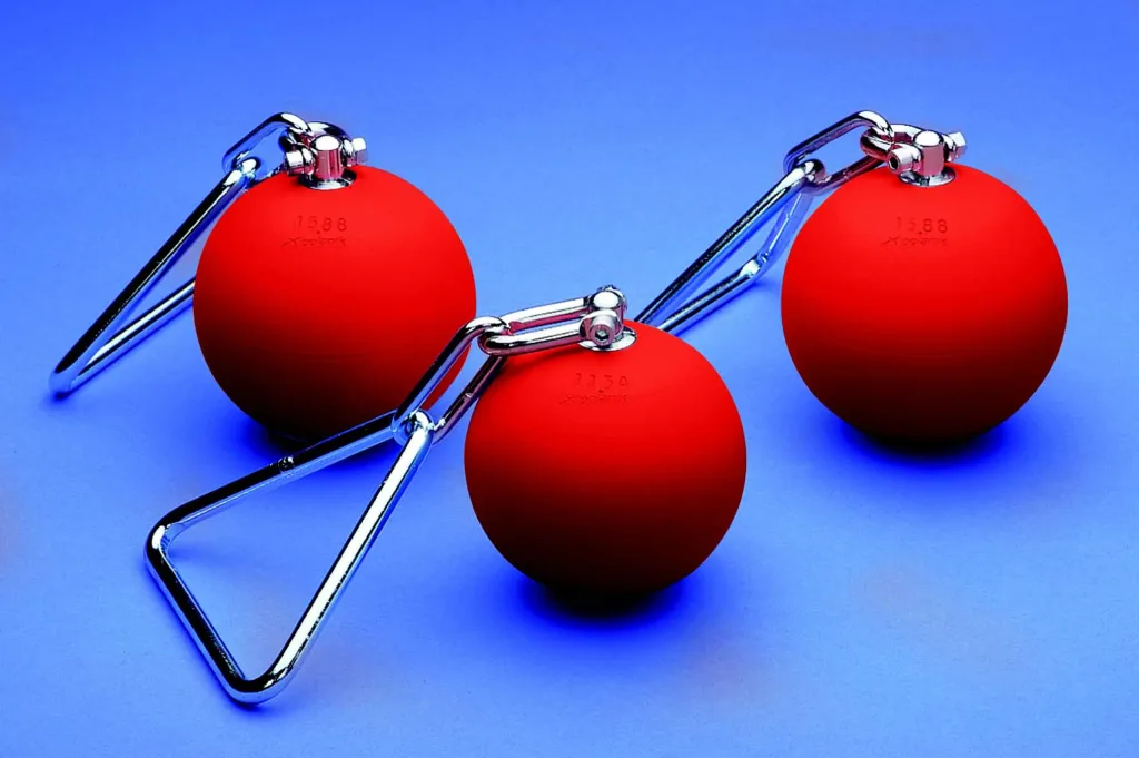 Three red powder-painted steel throwing weights with galvanised steel handles and chains on a blue background.