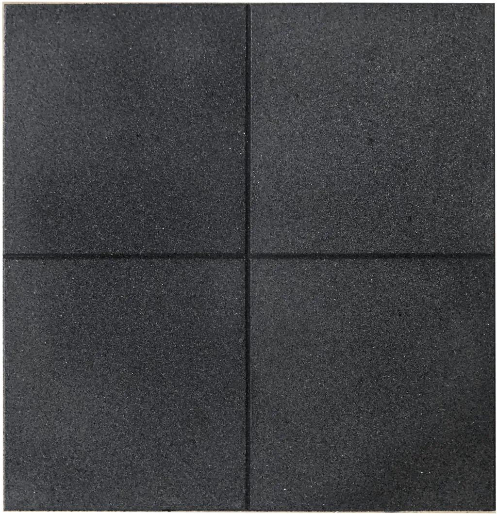 Black rubber floor tiles arranged in a four-tile grid with visible seams and a coarse textured surface.