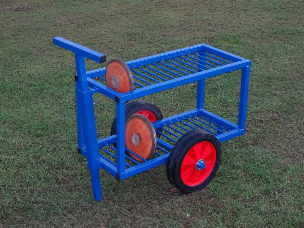 Blue powder-coated steel discus trolley with two slatted shelves, a T-shaped handle, red wheels, and two orange discus on the shelves.