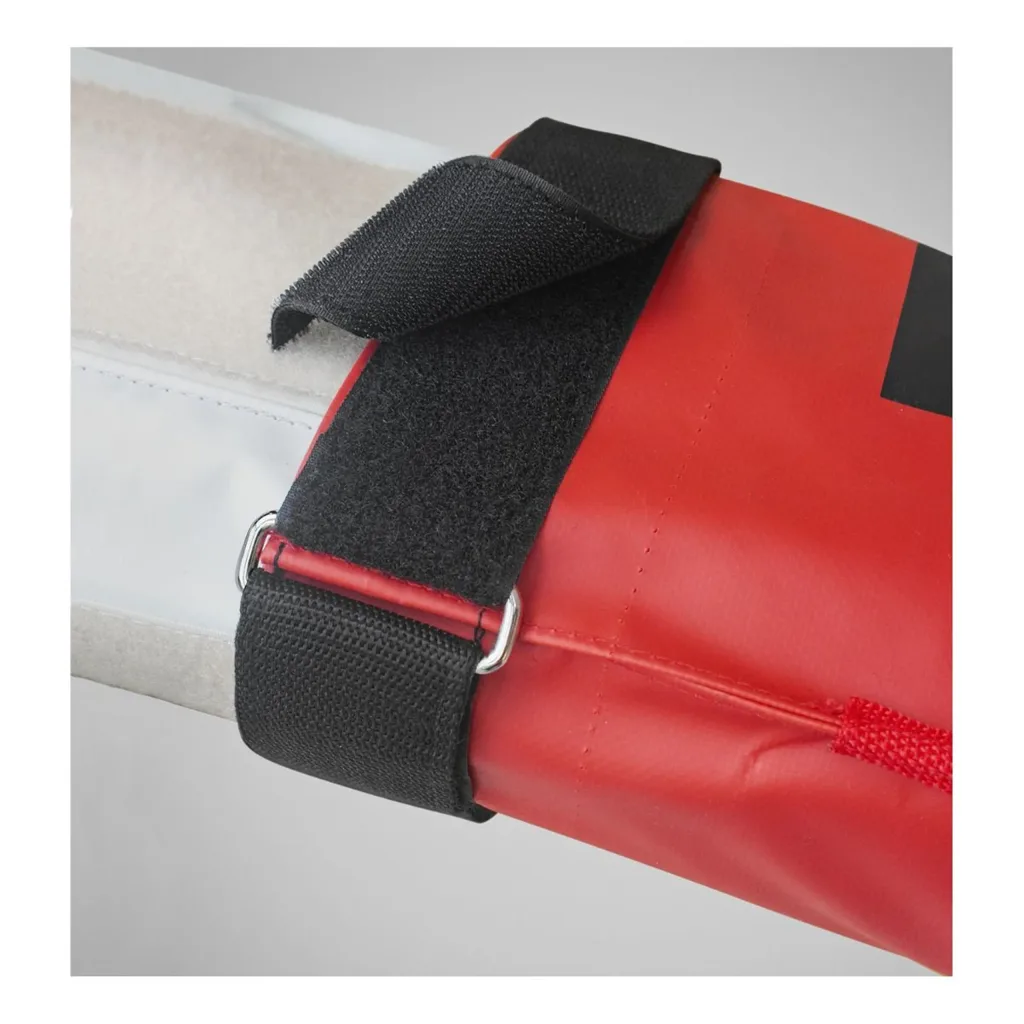 Red vinyl pole vault bag end with leather-reinforced edge and black hook-and-loop strap threaded through a metal D-ring securing a light-colored pole.