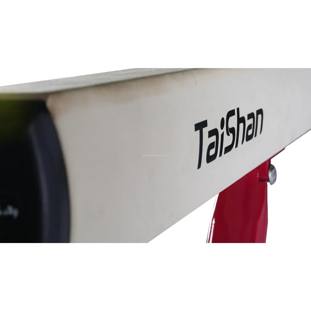 Competition balance beam with padded non-slip top, TaiShan printed on the side, and a red adjustable leg visible.