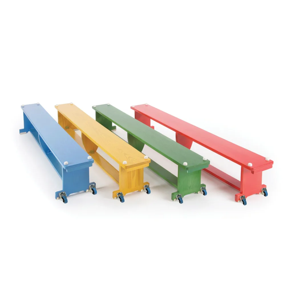 Four low aluminium benches with blue, yellow, green and red tops on rubber feet, arranged diagonally on a white background.