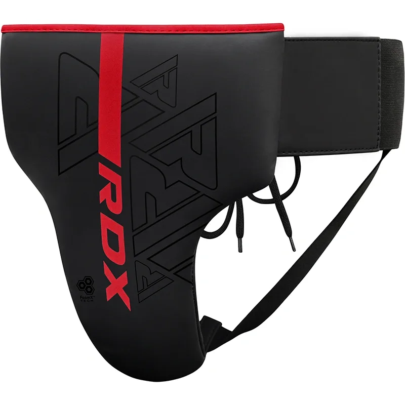 Black groin guard with RDX printed in red beside a vertical red stripe, lace ties and an elastic waistband visible.