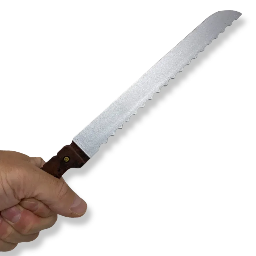 Hand holding a PU foam bread knife training prop used for police training, with a serrated silver blade and brown handle.