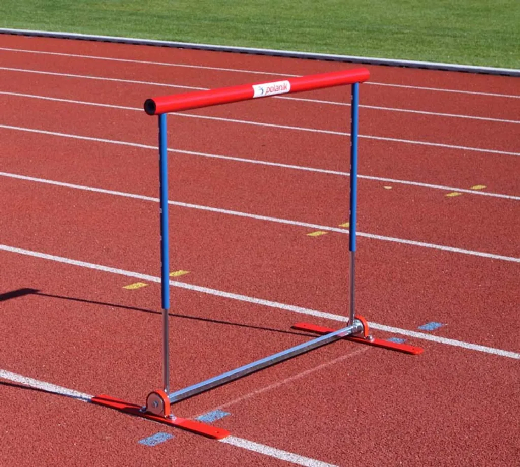 Spring-back hurdle with padded red top bar, aluminium telescopic blue uprights and galvanised steel frame on a red running track.