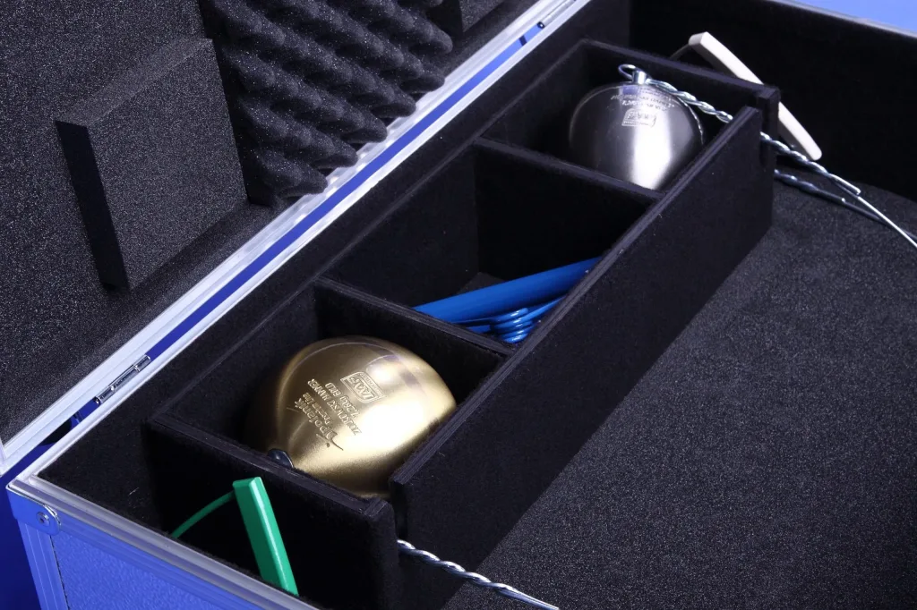 Aluminium hammer transport case upholstered with foam, showing three compartments holding two hammer heads and a handle.