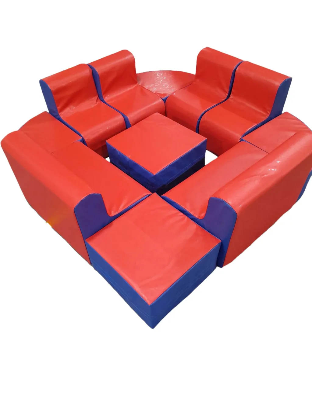 Soft foam seating arranged in an island with two small sofas, one chair, four wedge pouffes and a central ottoman with PVC covers.