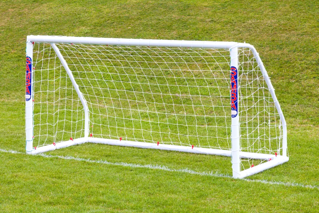 Portable freestanding uPVC soccer goal with net set on grass.