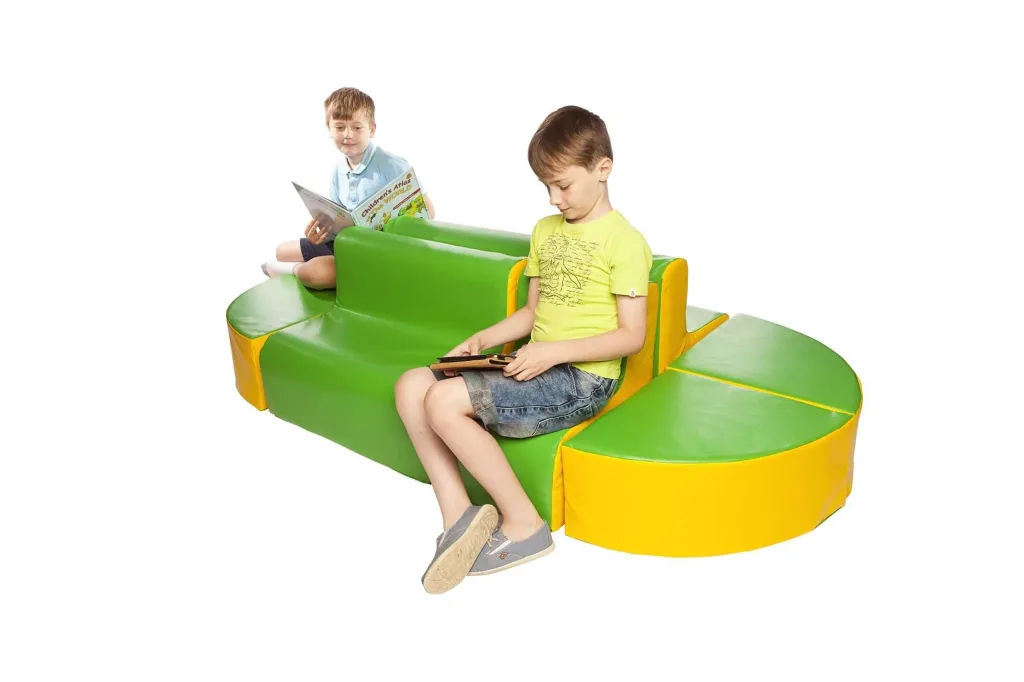 Green and yellow foam children's island seating set with two boys seated, featuring two sofas, one chair and four wedge pouffes with PVC covers.