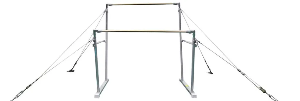 Uneven bars with two wooden rails on a metal frame supported by tension cables anchored outward.