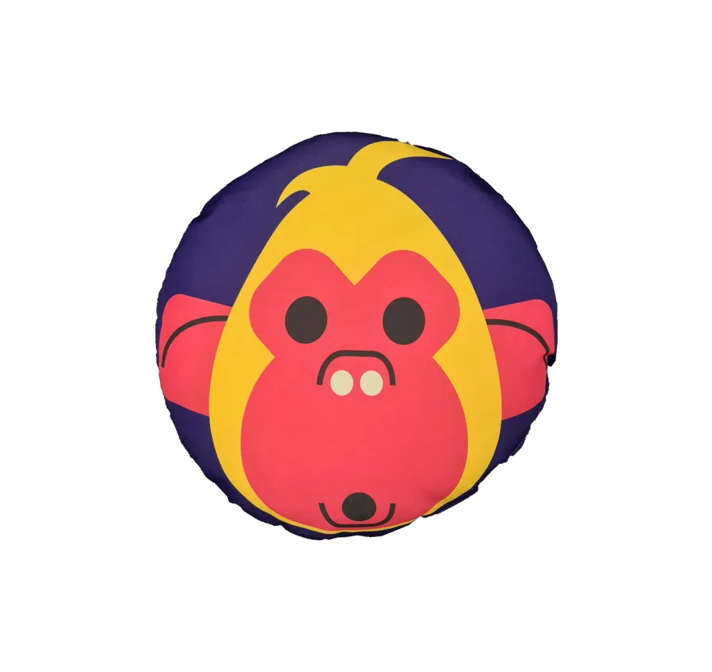 Round cushion with a stylized yellow and pink monkey face with black eyes on a purple background.