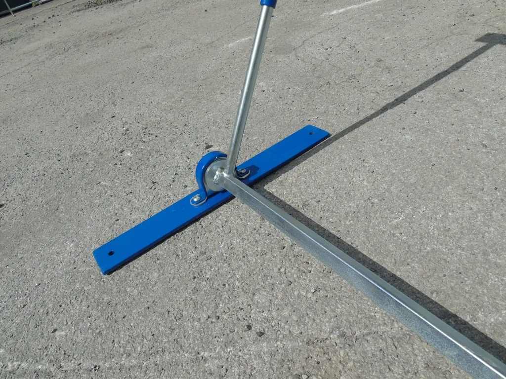 Blue padded steel hurdle base with upright and spring connector resting on asphalt.