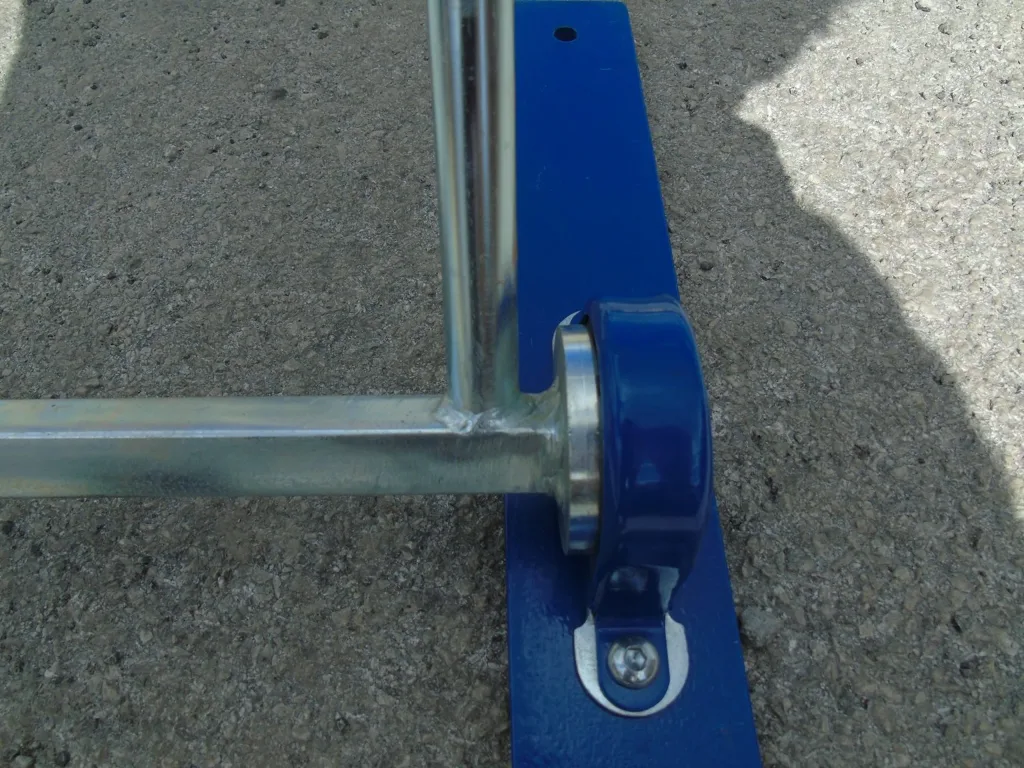 Close-up of a steel hurdle leg welded to a blue painted baseboard with a blue bracket and securing bolt.