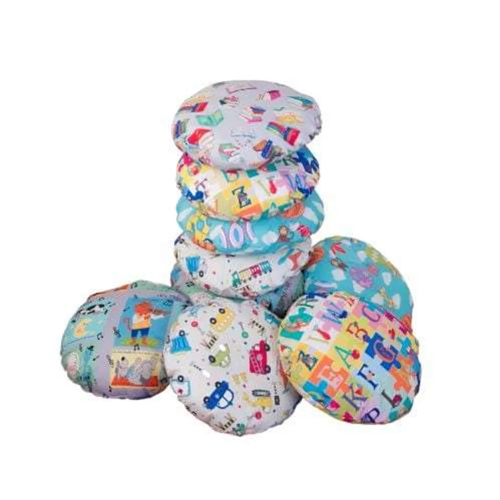 Stack of colorful round children's scatter cushions featuring assorted educational prints of letters, numbers and pictures.