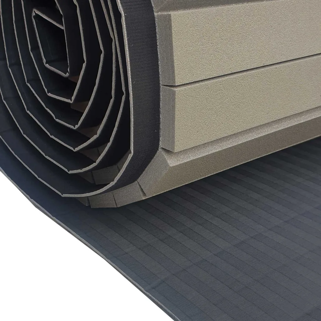 Rolled-up hybrid roll-out mat showing layered high-density cross-link foam core, PVC tatami-textured surface and black hook-and-loop edge.