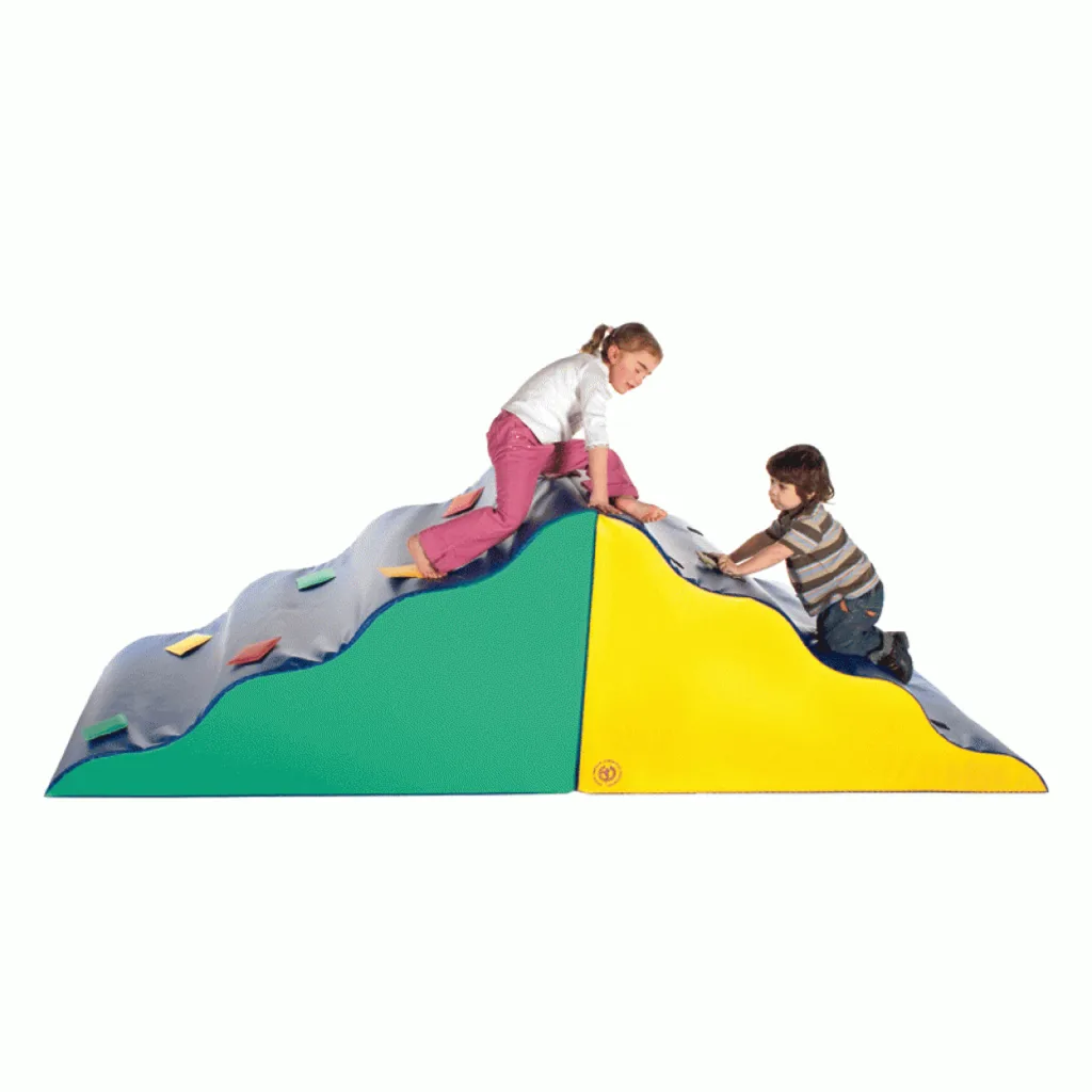 Two children climbing a green and yellow foam wave climber with a gray padded top studded with colored hook-and-loop patches.