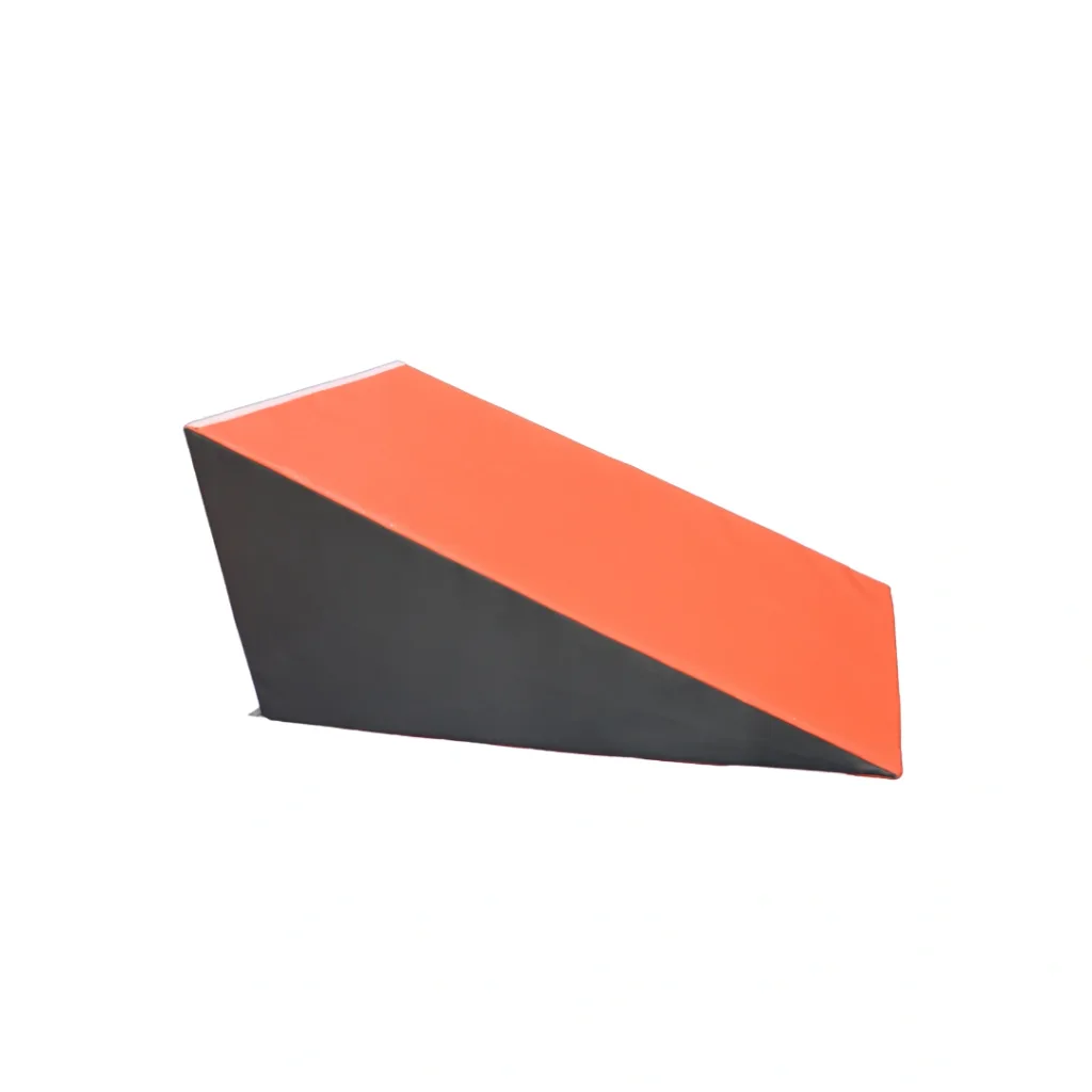 Orange and grey foam wedge from a gymnastics play set, sloped triangular ramp on a white background.