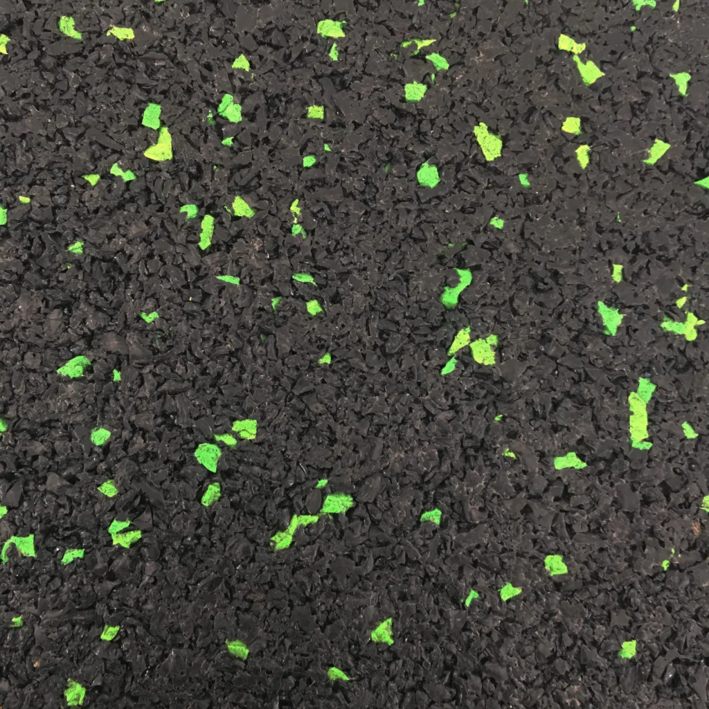 Black rubber flooring with scattered bright green flecks and a coarse granulated texture.