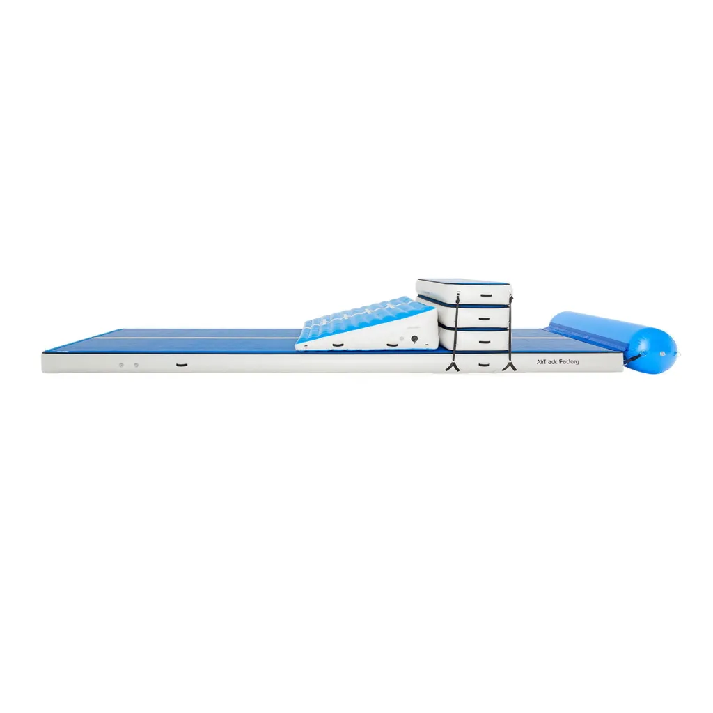 Inflatable blue and white air track mat with a wedge ramp, three stacked pads secured by straps, and a blue cylindrical bumper, text AirTrack Factory.