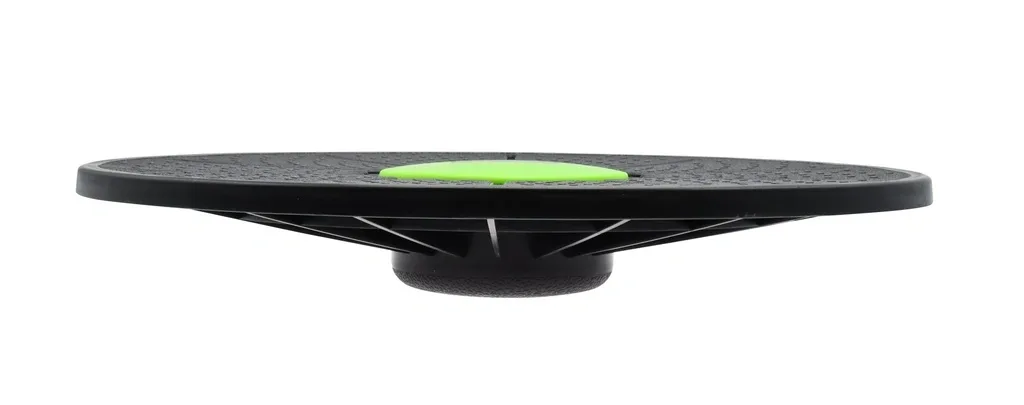 Low-angle view shows a circular black balance board made from heavy duty plastic with a bright green center disc.