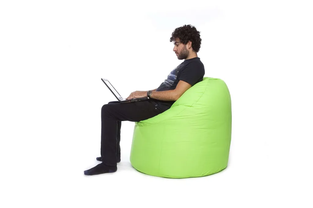 Man seated on a lime polyester teen/adult bean chair, leaning back while using a laptop.