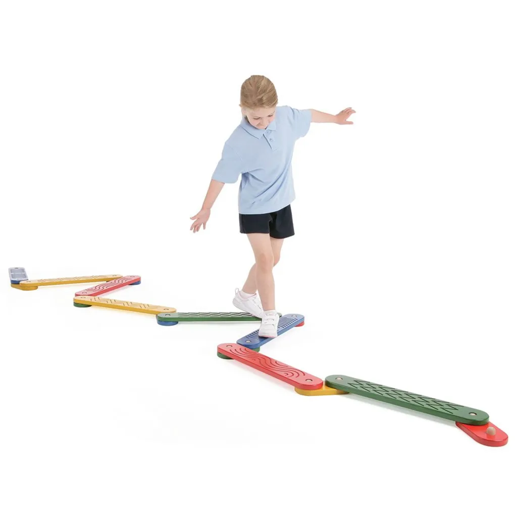 Child balancing along connected zigzag balance boards in red, blue, green and yellow on a white background.