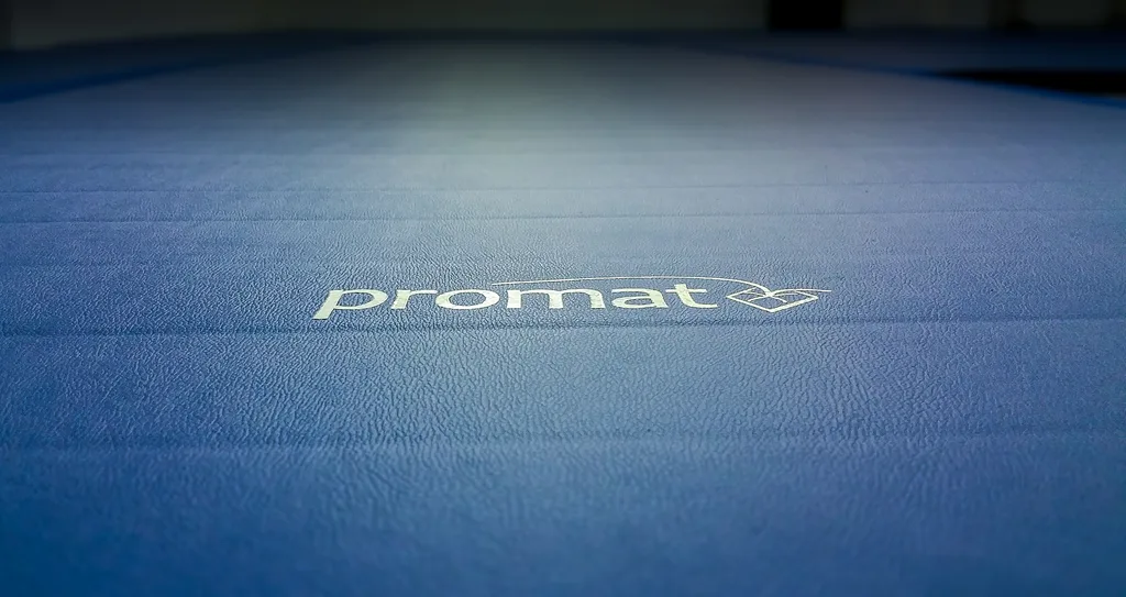 Blue textured mat with the white text promat and a small looped heart logo near the center.